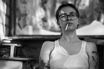 A woman with a cigarette strikes a pose in a black and white portrait.