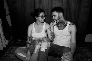 Intimate moment between a couple in black and white, enhanced by tattoos.