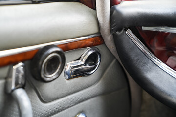 The inner door handles of a vintage car are captured in a clean view, reflecting the classic design...
