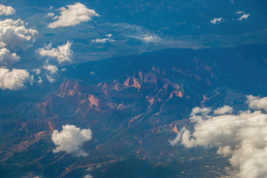 Aerial view of Timber Top Mountain at Zion National Park in Utah, USA with rugged red rock formations and clouds drifting across the canyon landscape