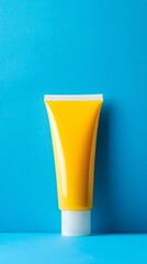 Yellow Squeeze Tube with White Cap on Blue Background, Minimalist Product Display