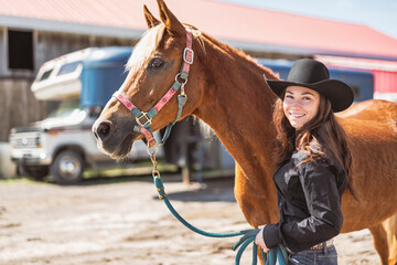 woman cowgirl, stands next to her horse in summer season