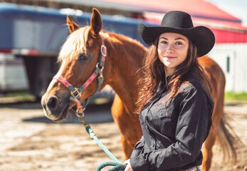 woman cowgirl, stands next to her horse in summer season