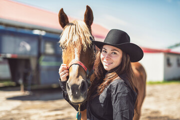 woman cowgirl, stands next to her horse in summer season