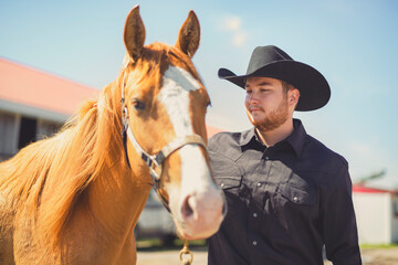 cowboy, stands next to her horse in summer season