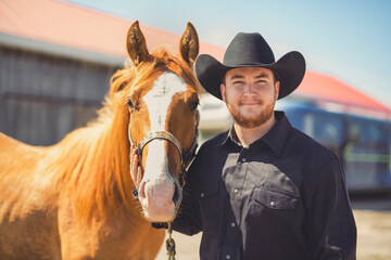 cowboy, stands next to her horse in summer season