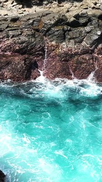 red; rocks; ocean; turquoise; waves; coast; crashing; sea; contrast; nature; scenic; dramatic; blue; vibrant; tropical; shoreline; splash; travel; power; rugged; marine; wild; island; energy; erosion;