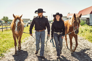 couple boyboy and girl, stands next to her horse in summer season