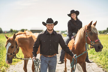couple boyboy and girl, stands next to her horse in summer season