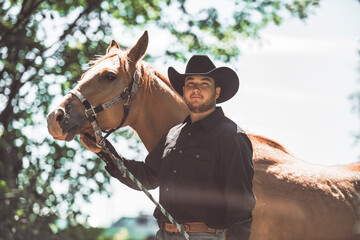 cowboy, stands next to her horse in summer season