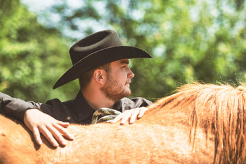 cowboy, stands next to her horse in summer season