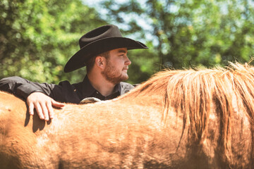 cowboy, stands next to her horse in summer season