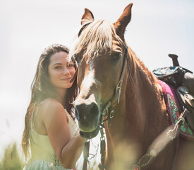 woman cowgirl, stands next to her horse in summer season
