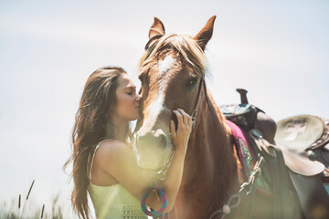 woman cowgirl, stands next to her horse in summer season