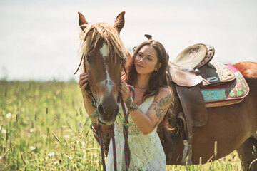 woman cowgirl, stands next to her horse in summer season
