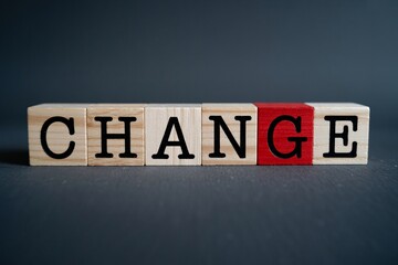 Obraz premium Wooden blocks spelling change with red letter g, symbolizing transformation, growth, and new beginnings.