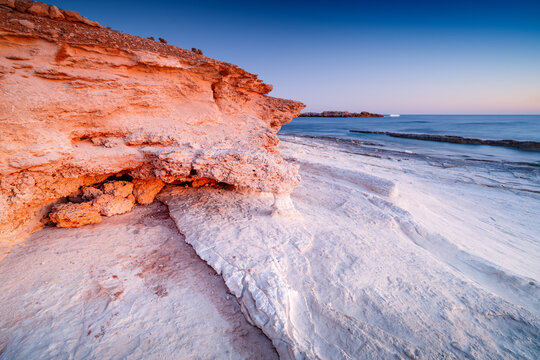 Beautiful rocks off the coast of Cyprus at sunset. Rocky shore of the Mediterranean Sea, Cyprus, Olive Tree beach, Paphos.