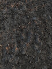 Dry soil with cracks and tiny rocks on top.