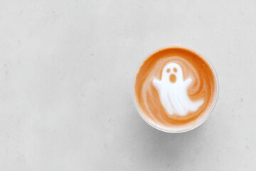 Ghostly Latte Art in Coffee Cup on Minimalist Background - Halloween Theme.