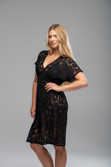 Fototapeta premium Beautiful blonde model in elegant lingerie posing confidently in studio setting with soft lighting. Fashion and beauty concept for advertising, catalogs, or editorial content.