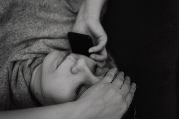 A woman lies on a couch appearing anxious as she talks on the phone Her hand rests on her forehead...