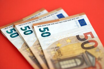 Big amount of european euro currency money notes on red color table close up