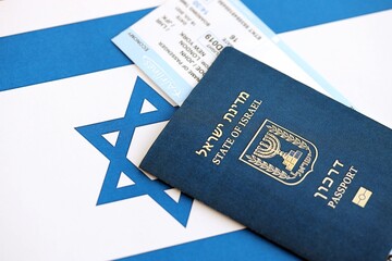 Israel passport and tickets on flag. The current Israel biometrical pass lies on flag close up