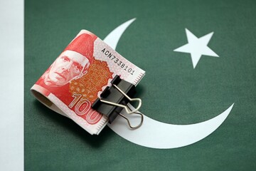Pakistan rupees banknotes on Pakistani flag. The current Pakistan money bills