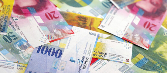 Swiss franc banknotes. The current francs money bills lies on table in big amount