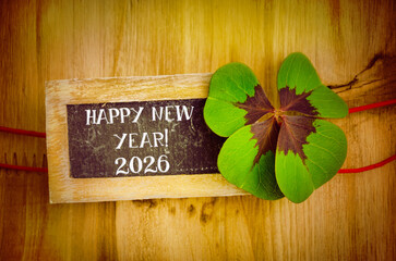 HAPPY NEW YEAR 2026 decoration with four leaf clover and chalkboard inscribe in english
