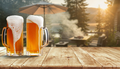 Glass of beer on wooden garden table – backyard relaxation at home. In the blurred background, a lush green garden and barbecue grill and patio area with outdoor furniture behind a house.