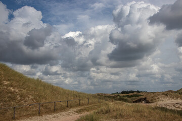 Sand Dune Landscape with Grassy Hills and Dramatic Summer Clouds