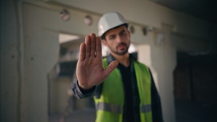 Serious dissatisfied Caucasian man showing hand gesture stop deny no build male guy builder reject...