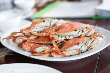Fresh sea crabs cooked by charcoal grilling, served on the dish with Thai seafood dipping sauce at the famous local restaurant in Thailand.