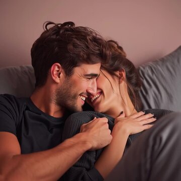 Happy couple laughing and cuddling in bed