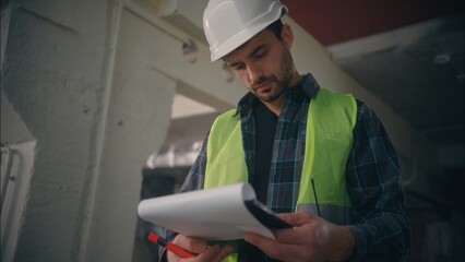 Serious Caucasian male engineer mechanic builder man writing tablet foreman guy planning draft...