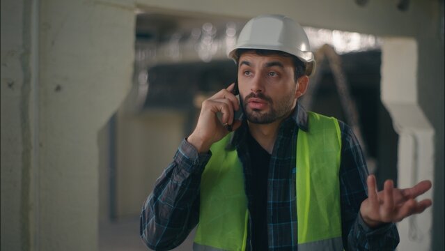 Irritated Caucasian man builder speaking call mobile phone quarrel in construction foreman contractor electrician male communicating smartphone inspector handyman guy arguing problem work difficulty - Powered by Adobe