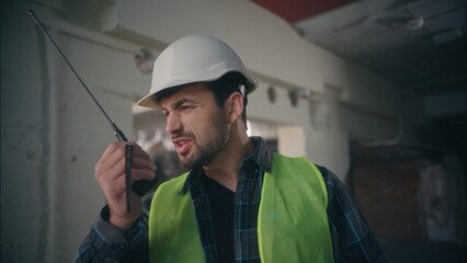 Furious irritated Caucasian workman architect foreman talking walkie talkie guy handyman inspector...