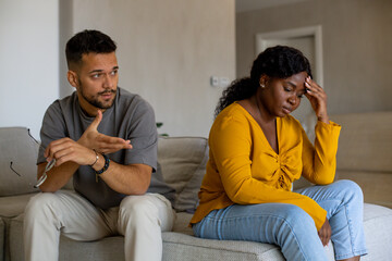Couple fighting at home sitting on the sofa.