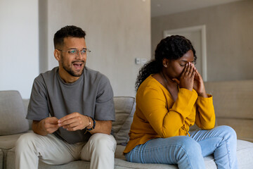 Couple fighting at home sitting on the sofa.