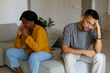Couple fighting at home sitting on the sofa.