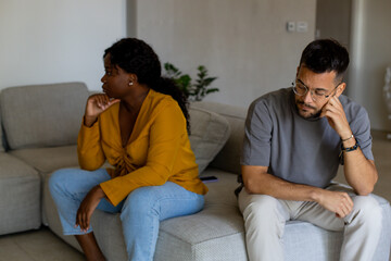 Couple fighting at home sitting on the sofa.