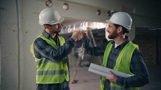 Friends colleagues Caucasian men greeting meeting support gesture hit with fists males guys construction builders contractors civil engineers build partners teamwork architects workers respect hands