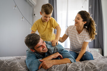 Obraz premium Happy young caucasian family being playful and having fun together in the living room at home