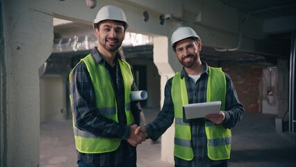 Two joyful smiling Caucasian architects guys colleagues men technicians talking conversation males...