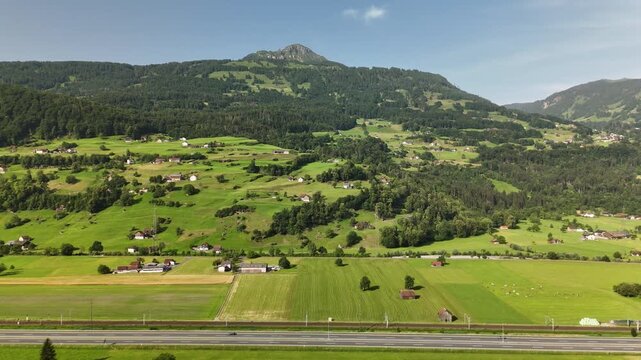 Scenic Aerial View of a Valley with Green Fields and Mountain Landscape in Switzerland near Flums, Berschis, and Walenstadt in the Canton of St. Gallen &ndash; Drone Footage