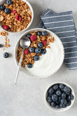 Greek yogurt bowl with granola and berries topping, top view copy space. Healthy meal