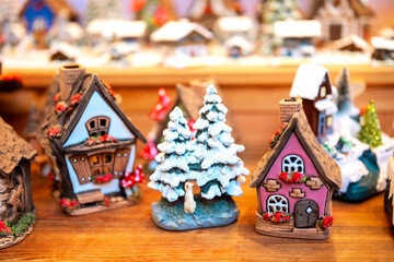Miniature snowy cottages and trees figurines at Christmas market for artisan miniatures concept