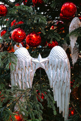 Red Christmas baubles on tree with angel wings for festive tradition concept