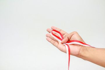 Commemorating Indonesia's Independence Day: A hand holds the red and white ribbon
